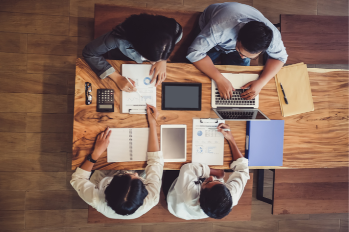A Team Of Virtual Marketing Assistants Working Around A Table
